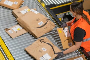 female amazon warehouse worker with many parcels and boxes