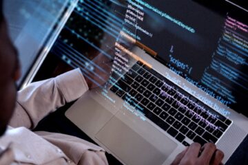 computer program developer writing code on laptop