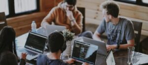 team working on laptops at common table
