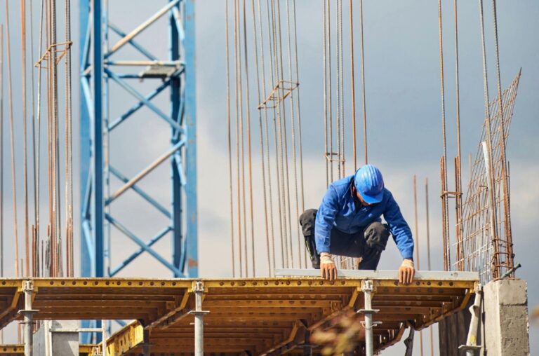 man leveling cement form on office tower
